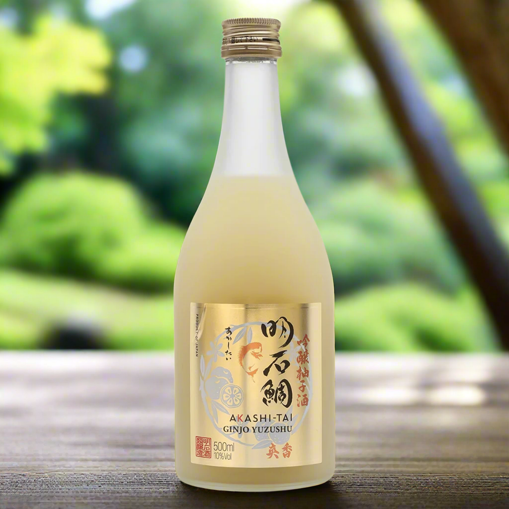 Akashi Tai Ginjo Yuzushu Sake bottle with sliced yuzu in a Japanese garden setting