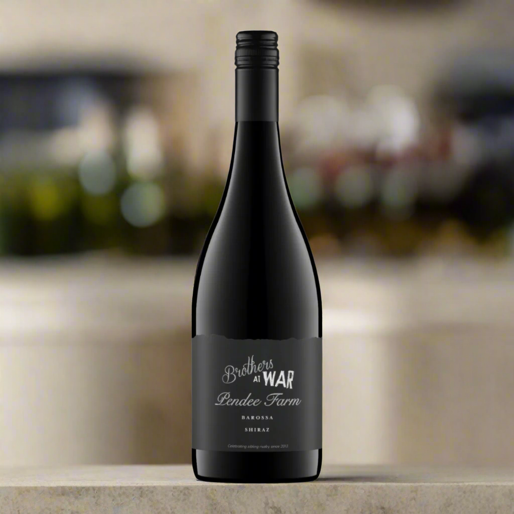 Place a bottle of Brothers at War Pendee Farm Shiraz on a sleek, minimalist surface with a backdrop of Barossa Valley vineyards and large windows letting in natural light.