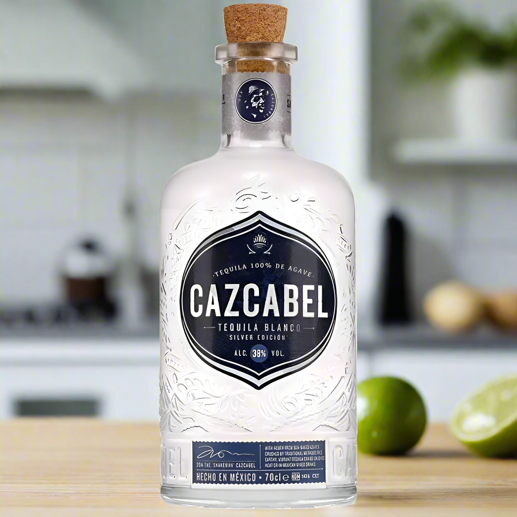 Cazcabel Tequila Blanco bottle on modern kitchen counter with limes and salt