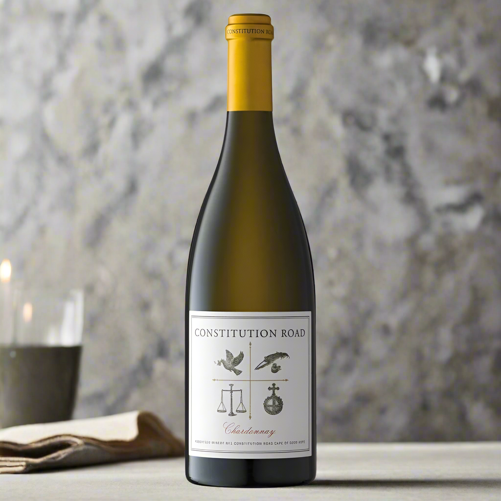 Place a bottle of Constitution Road Chardonnay on a candlelit dining table with elegant tableware and soft shadows, evoking a refined evening atmosphere.