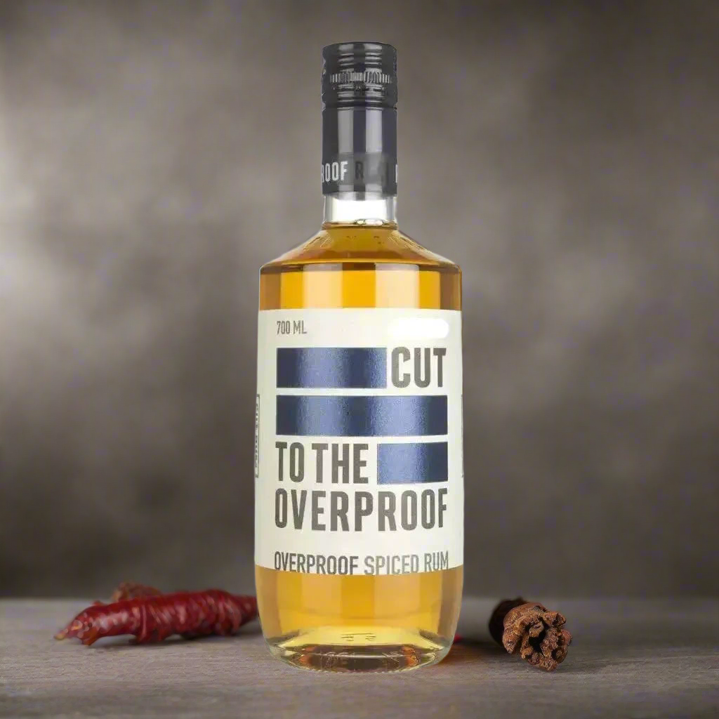 Underground Speakeasy with a Gritty Vibe
A moody, urban speakeasy with concrete walls, industrial lighting, and a smoky atmosphere. The bottle of Cut To The Overproof Rum takes centre stage on a weathered bar top, beside a metal jigger, a rocks glass with a bold cocktail, and scattered cloves or chilli flakes. The scene exudes power, edge, and late-night energy—ideal for an overproof rum.