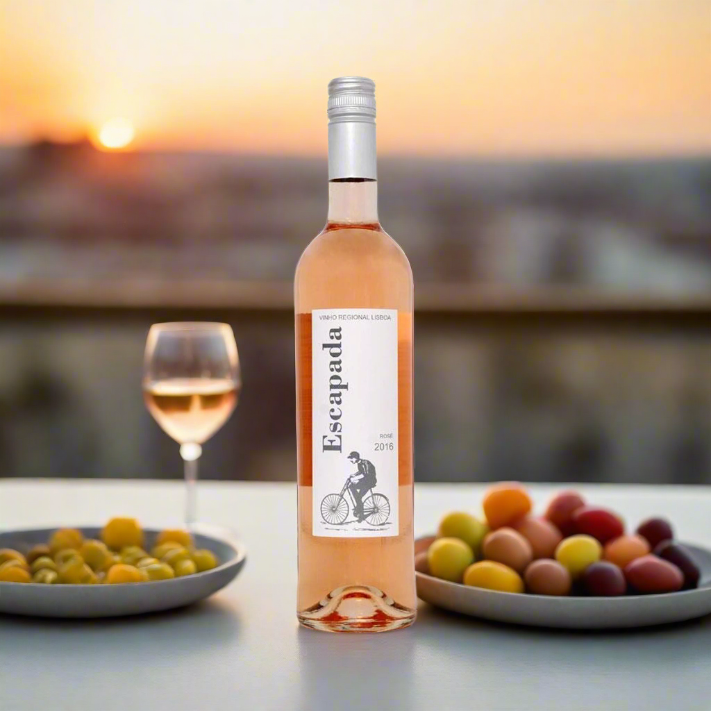 Rooftop Aperitif at Golden Hour
A chic rooftop scene with soft golden light, blush-toned skies, and a table set with olives, bruschetta, and a bottle of chilled Escapada Vinho Rosé. Friends clinking glasses in the background adds a celebratory, carefree feel.