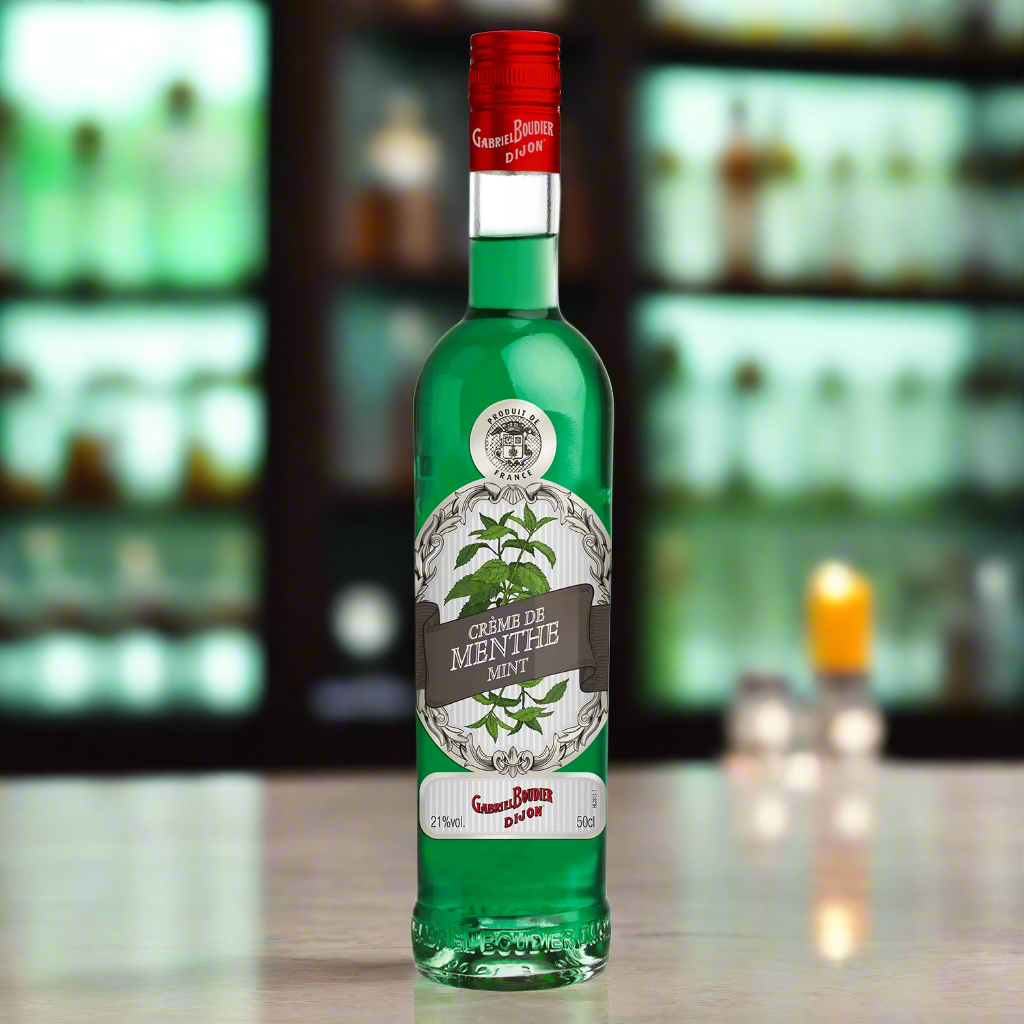Green bottle with red cap on a bar counter with blurred shelves in the background