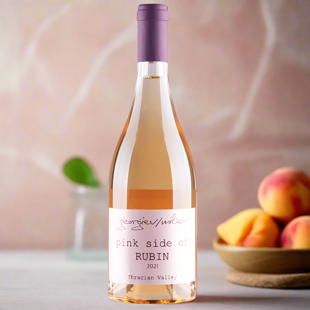 Rosé wine on marble counter with peaches and basil in a soft modern kitchen