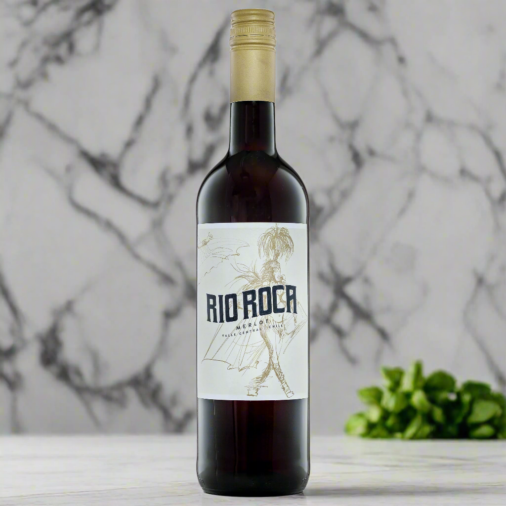 Rio Roca Merlot bottle on marble kitchen counter with basil leaves and warm light