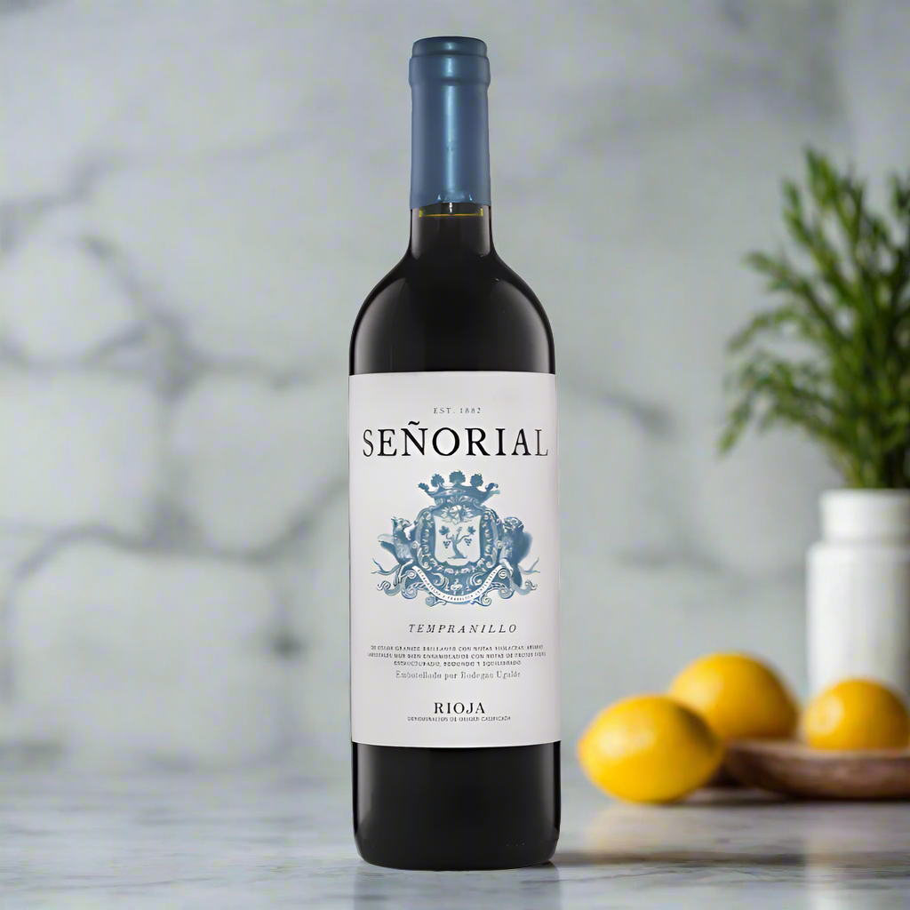Rioja red wine bottle on marble kitchen counter with herbs and lemon slices