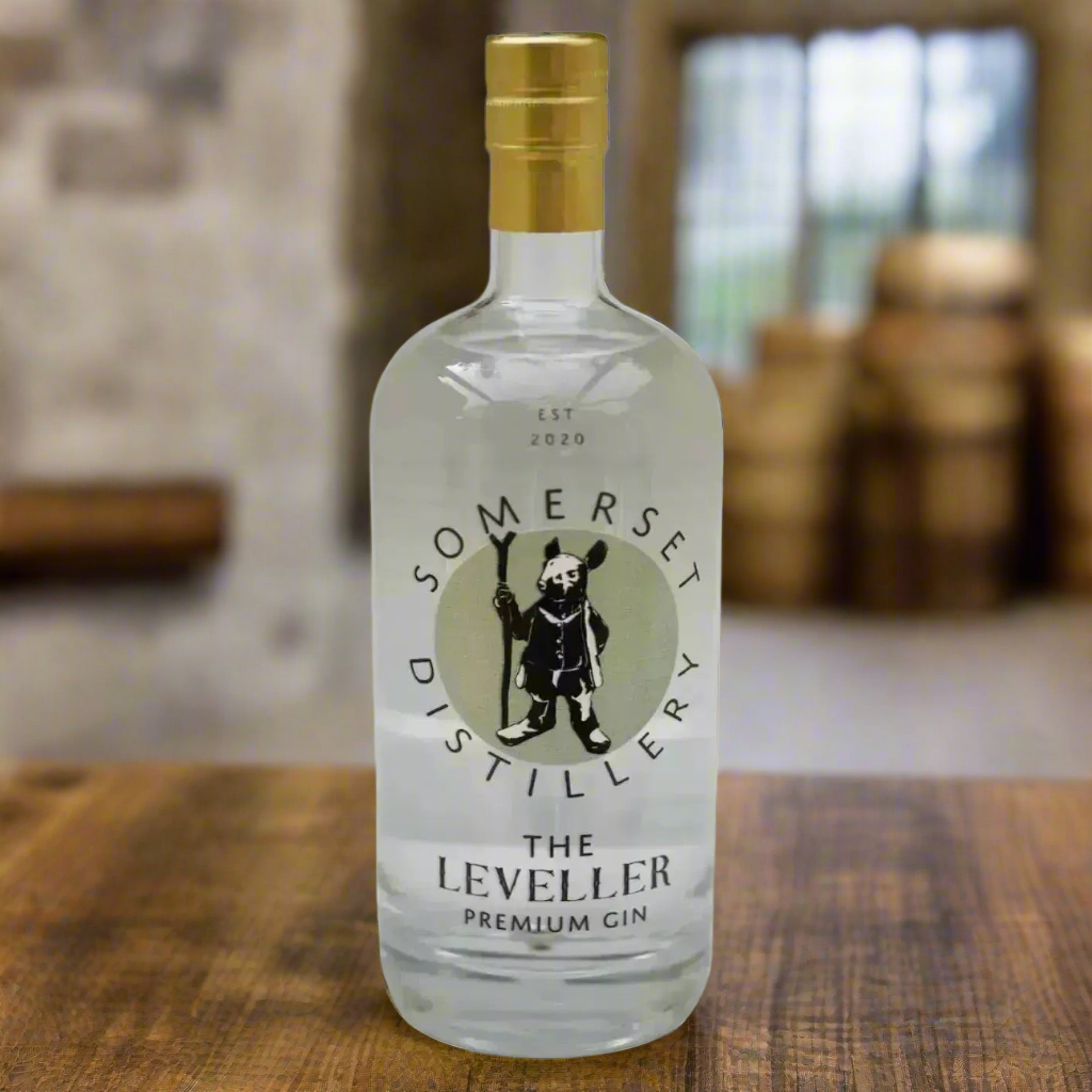 Rustic Distillery Setting in Somerset
An old stone barn or copper still room with warm lighting, wooden barrels, and copper distillation equipment subtly in the background. A bottle of The Leveller sits on a worn oak table, flanked by a neatly garnished G&T—ideal for showcasing craftsmanship and authenticity.