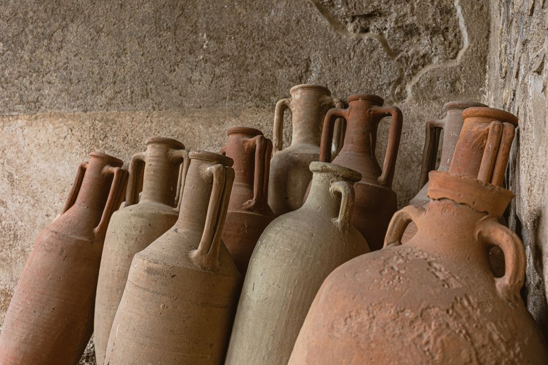 Ancient wine amphorae near a stone wall