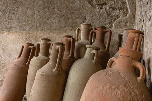Ancient wine amphorae near a stone wall