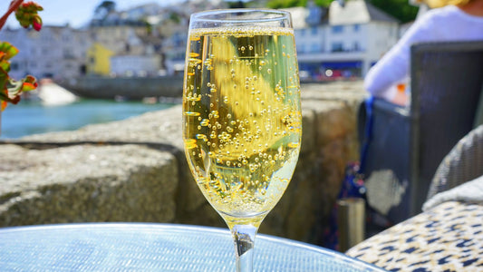 Champagne flute with golden bubbles at a sunny Mediterranean harbour