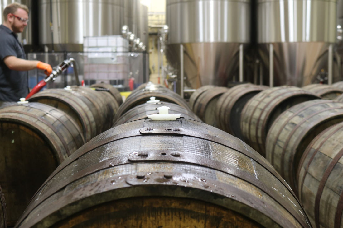 Brewer working among wooden barrels in a craft brewery