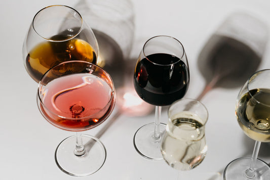 Three wine glasses showing rosé, red and white wine colours