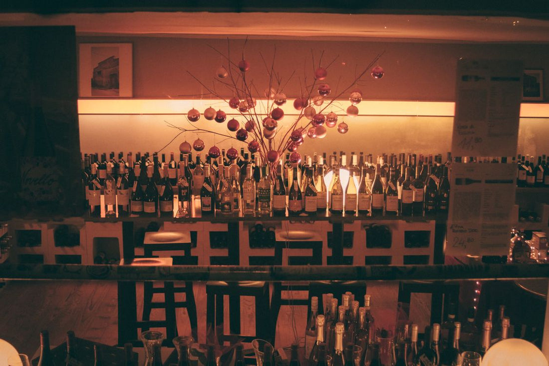 A lit wine bar with Christmas bottle displays and festive decorations