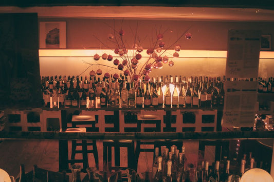 A lit wine bar with Christmas bottle displays and festive decorations
