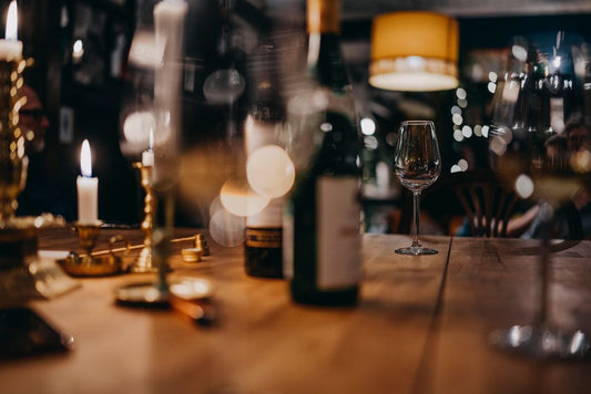 Candlelit wine tasting table with glasses and bottles