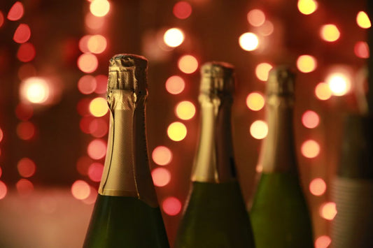 Four sparkling wine bottles with warm bokeh lights