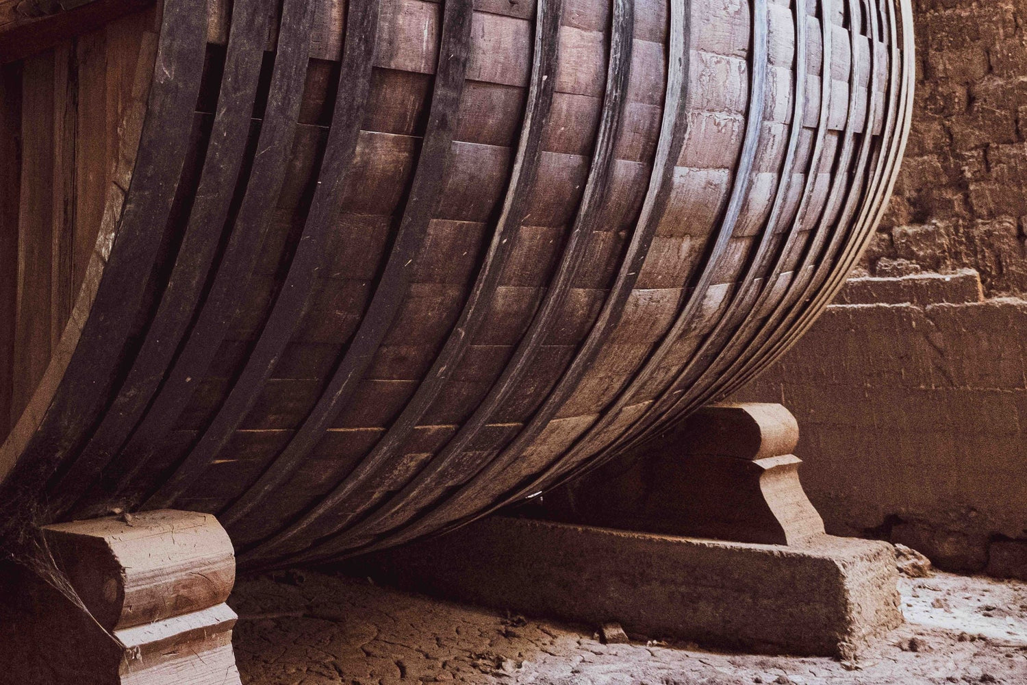 Vast ancient oak barrels in a traditional stone-walled wine cellar — Bodega Jesús Madrazo, Rioja, Spain
