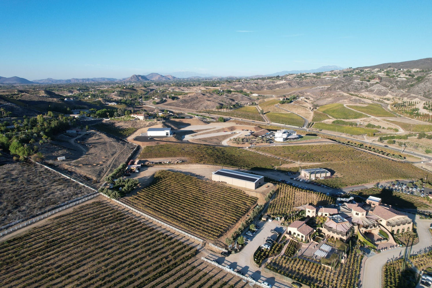 Aerial view of a large winery estate with vineyard rows and dry rolling hills in the background, Caliterra, Colchagua Valley, Chile