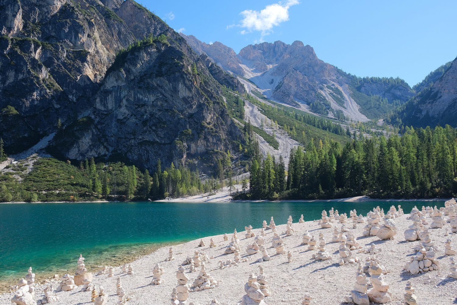 Stone cairns on the white pebble shore of turquoise Lago di Braies beneath Dolomite peaks, Alto Adige, Italy. Photo: kallerna (CC BY-SA 4.0)
