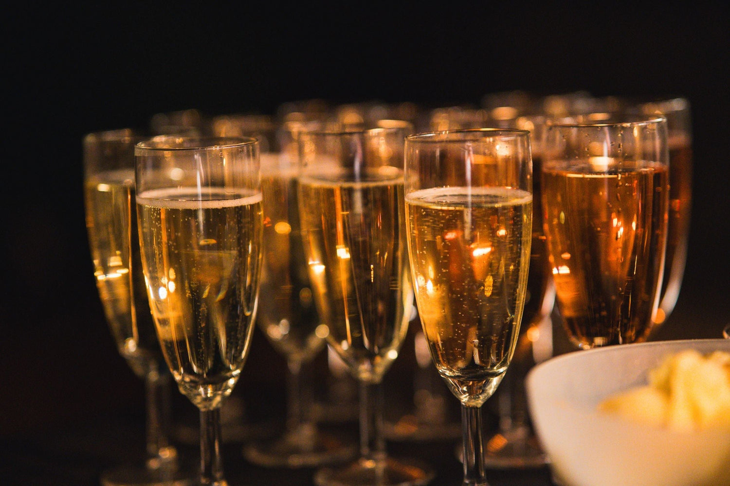 Rows of champagne flutes filled with golden sparkling wine with fine bubbles, ready for a celebration, Champagne