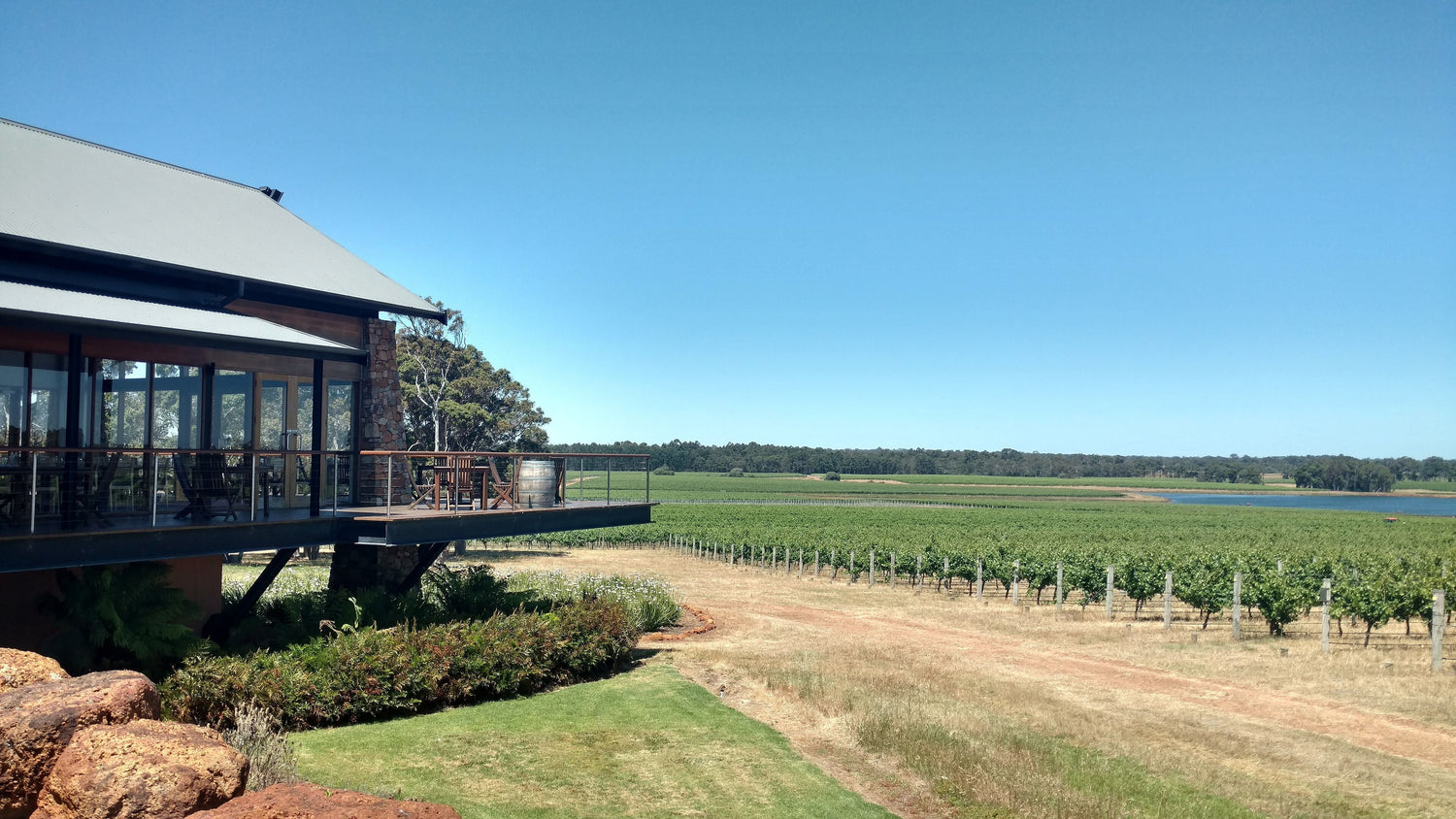 Modern winery building with deck overlooking green vineyard and a lake, Margaret River, Western Australia. Photo: Lasthib (CC BY-SA 4.0)