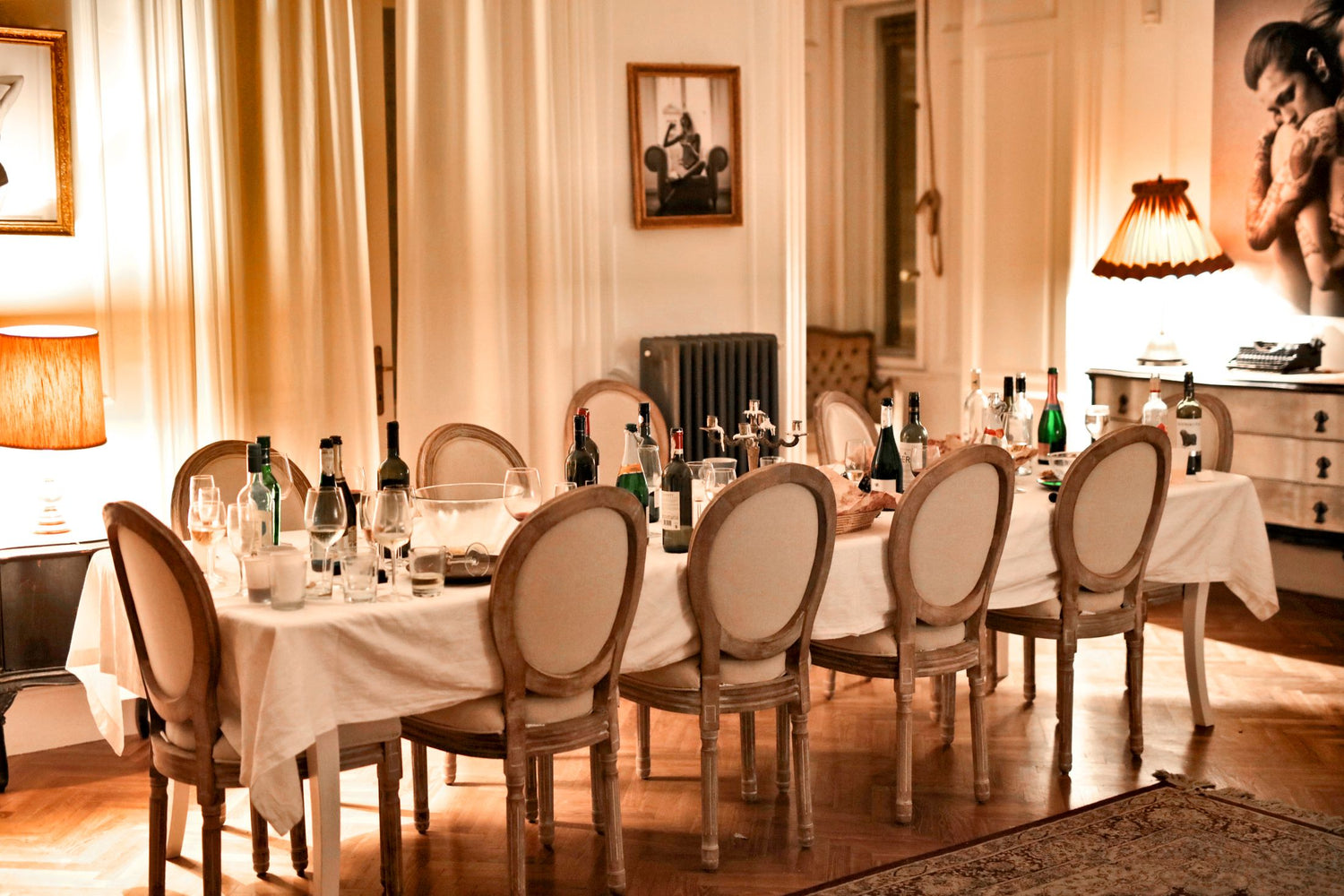 Long banquet table set with wine bottles and elegant oval-backed chairs, ready for a formal dinner with magnum-format wines