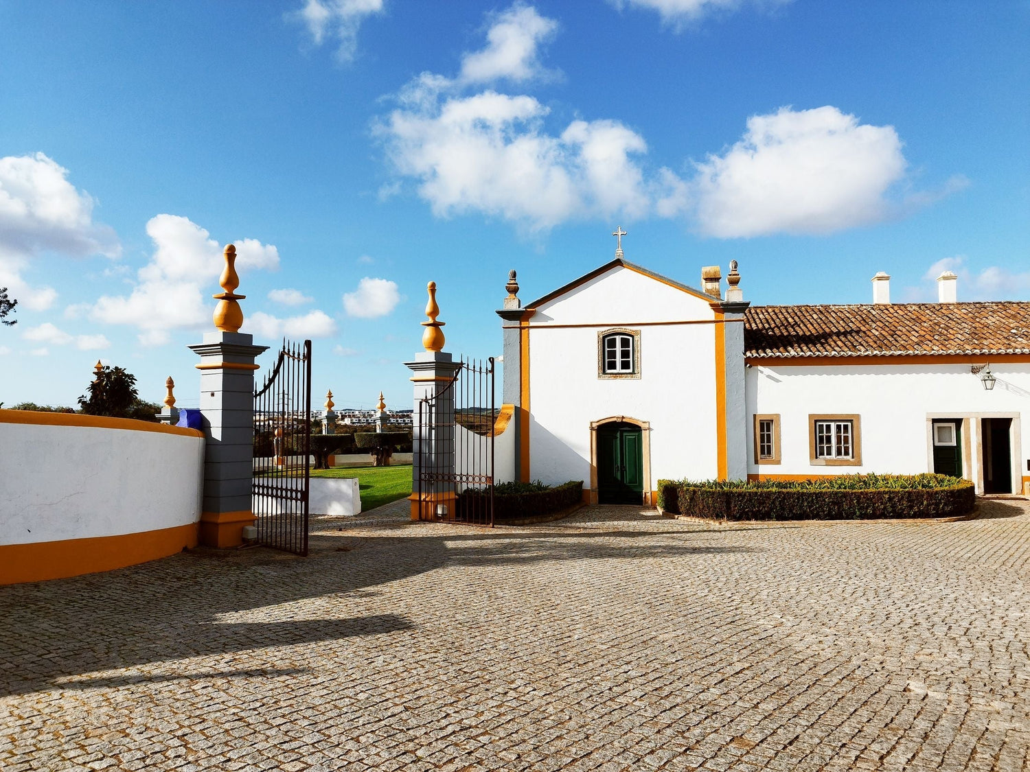 Whitewashed quinta estate courtyard with ornate iron gate and chapel in the Setúbal Peninsula, Portugal