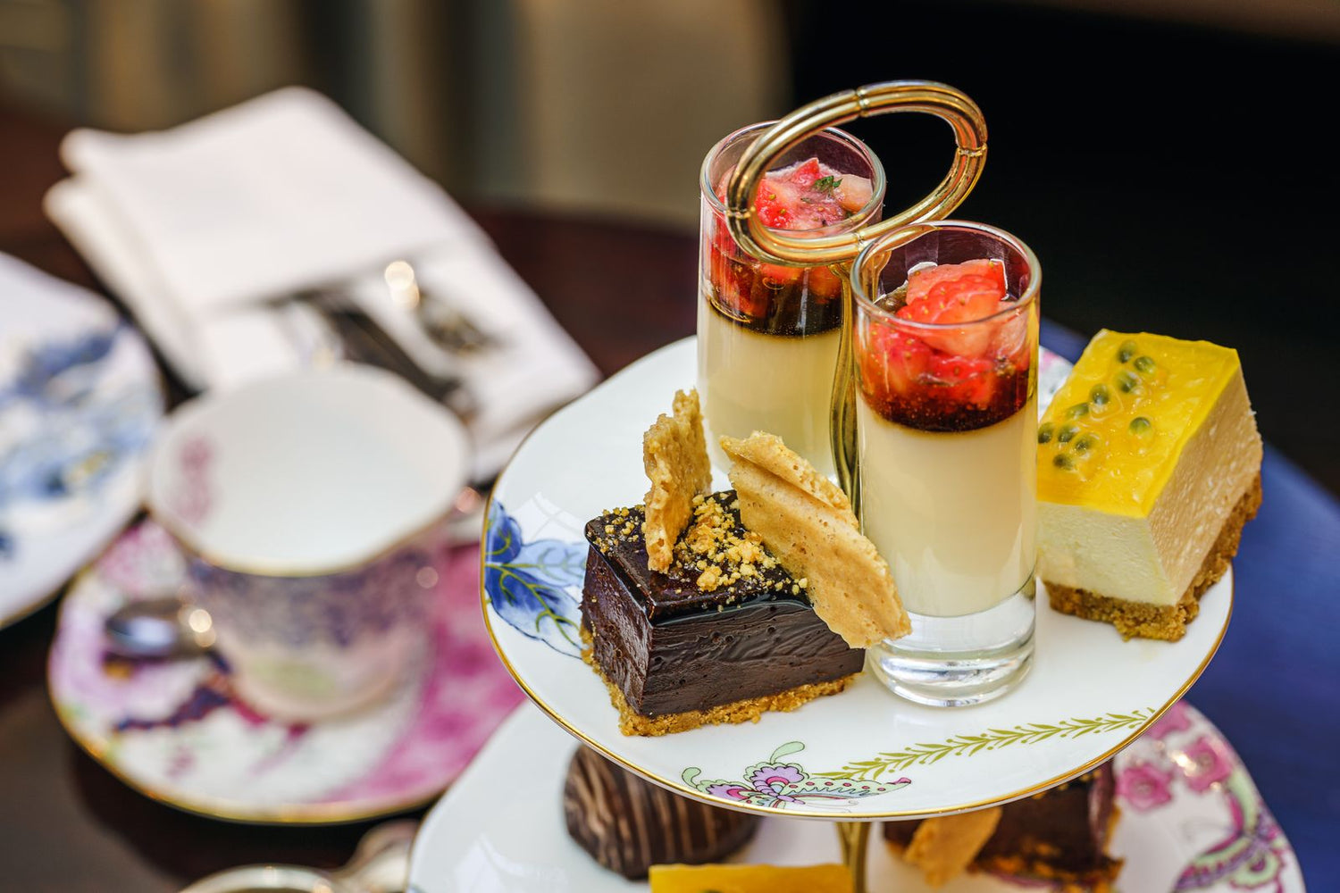 Tiered dessert stand with chocolate tart, panna cotta shots, passion fruit mousse and shortbread on fine bone china — wine pairing for desserts