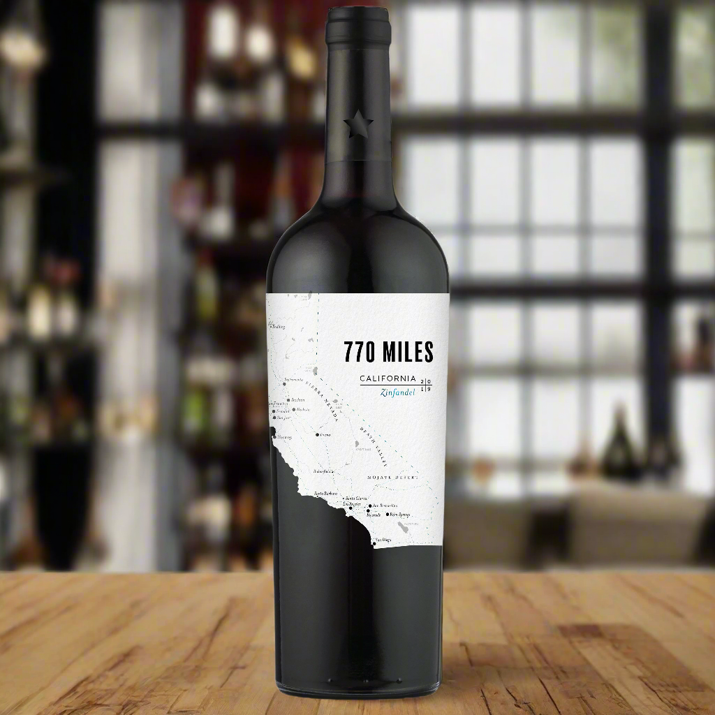Place a bottle of 770 Miles Zinfandel on a modern bar counter with an industrial-style urban loft backdrop, creating a sleek, contemporary vibe.