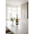 A.R. Lenoble Brut Intense Champagne bottle displayed on a marble kitchen island in a bright modern home prepared for a celebration.