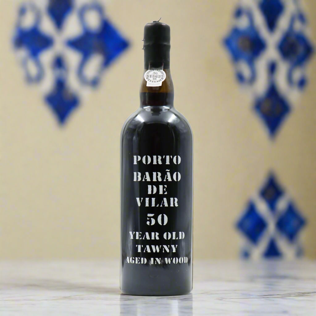 Barão de Vilar 50 Year Old Tawny Port bottle with azulejo tiles and marble table in classic Portuguese villa setting.
