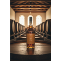 Blandy’s Bual 10 Year Old Madeira wine bottle displayed on an oak barrel inside a traditional Madeira wine lodge.