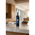 Bodegas Juan Gil Blue Label Jumilla wine bottle displayed on a natural-stone dining table in a bright contemporary kitchen and entertaining space.