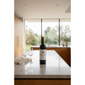Chateau Musar 2017 red wine bottle displayed on a modern stone kitchen island in a bright contemporary home.