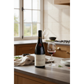 Domaine Georges Joillot Pommard wine bottle displayed on a natural stone worktop in an elegant French country kitchen.
