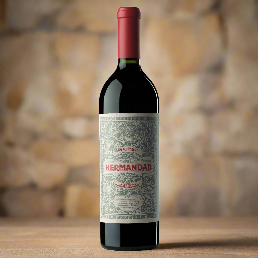 Falasco Hermandad Malbec bottle on barrel in atmospheric stone cellar