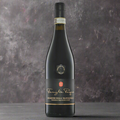 “Famiglia Pasqua Amarone della Valpolicella bottle on a dark stone surface with figs, cocoa nibs, and herbs. Minimalist, dramatic lighting with a sleek, contemporary backdrop.”