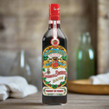 Rustic French countryside kitchen scene with bunches of blackcurrants, aged wooden table, vintage glass bottles and linen cloth, warm diffused light for a heritage Dijon feel