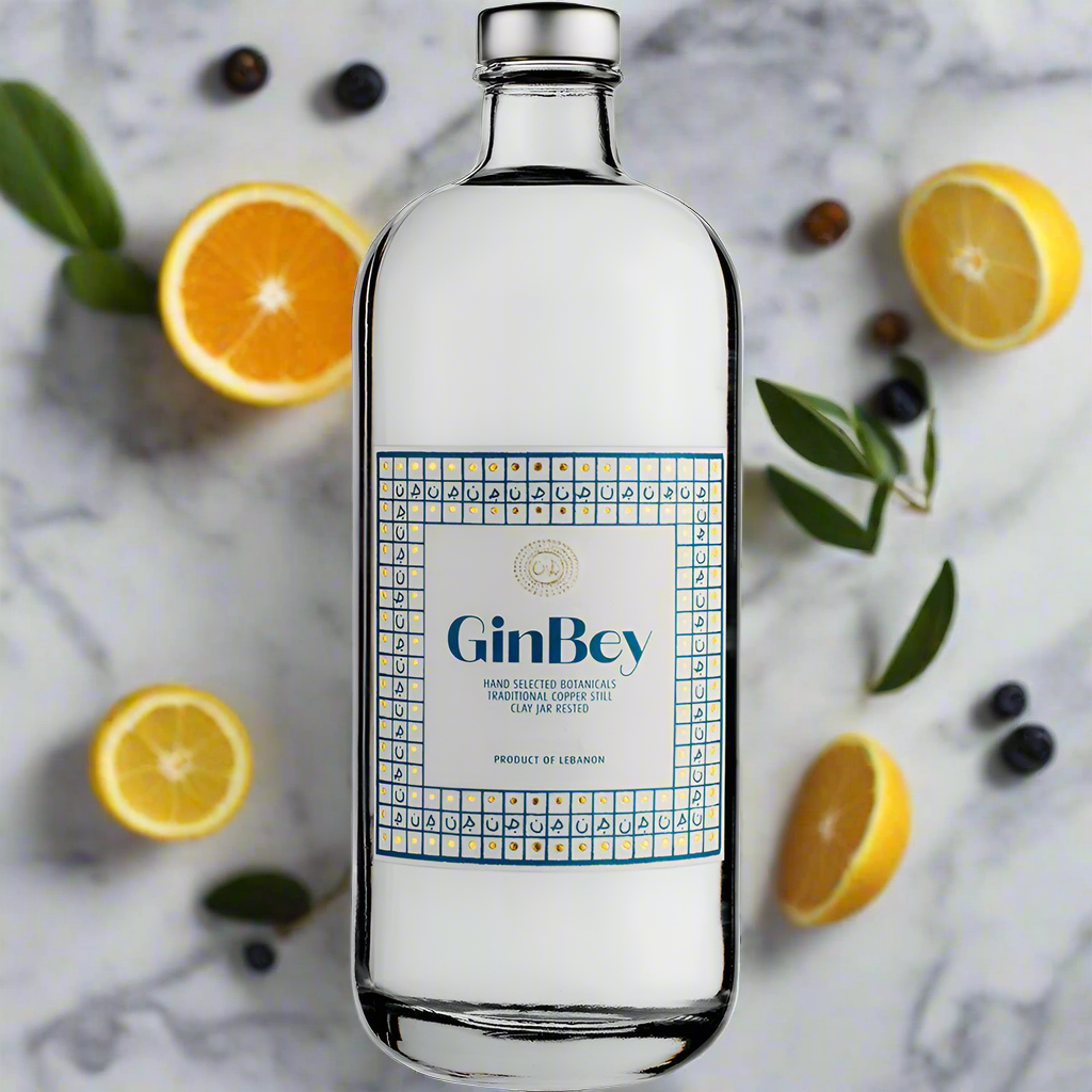 GinBey Gin bottle with citrus and botanicals bursting around on marble background