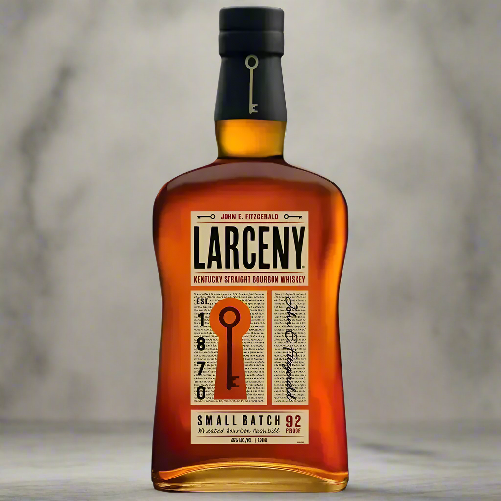 Bottle of Larceny Kentucky Straight Bourbon on marble counter with copper bar tools