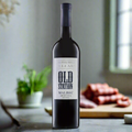 Old Station Malbec bottle on modern kitchen counter with chorizo and herbs