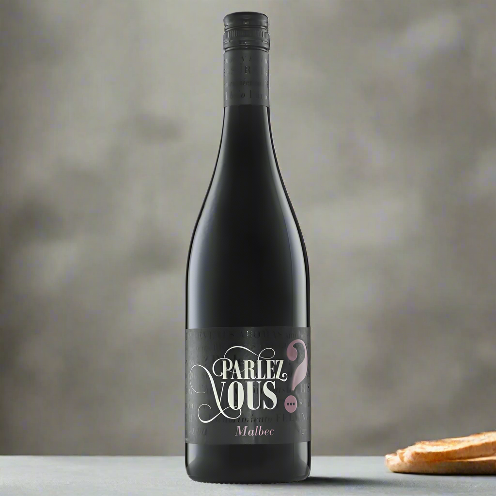 Parlez Vous Malbec bottle on modern dining table with cheese and bread