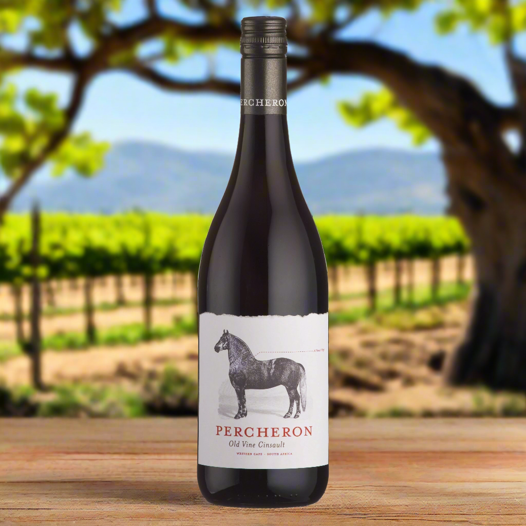 Place a bottle of Percheron Old Vine Cinsault on a rustic wooden table with the backdrop of sun-drenched old vines in a South African vineyard. The gnarled, twisting vines stretch across the landscape, capturing the essence of the vineyard’s rich history and character.