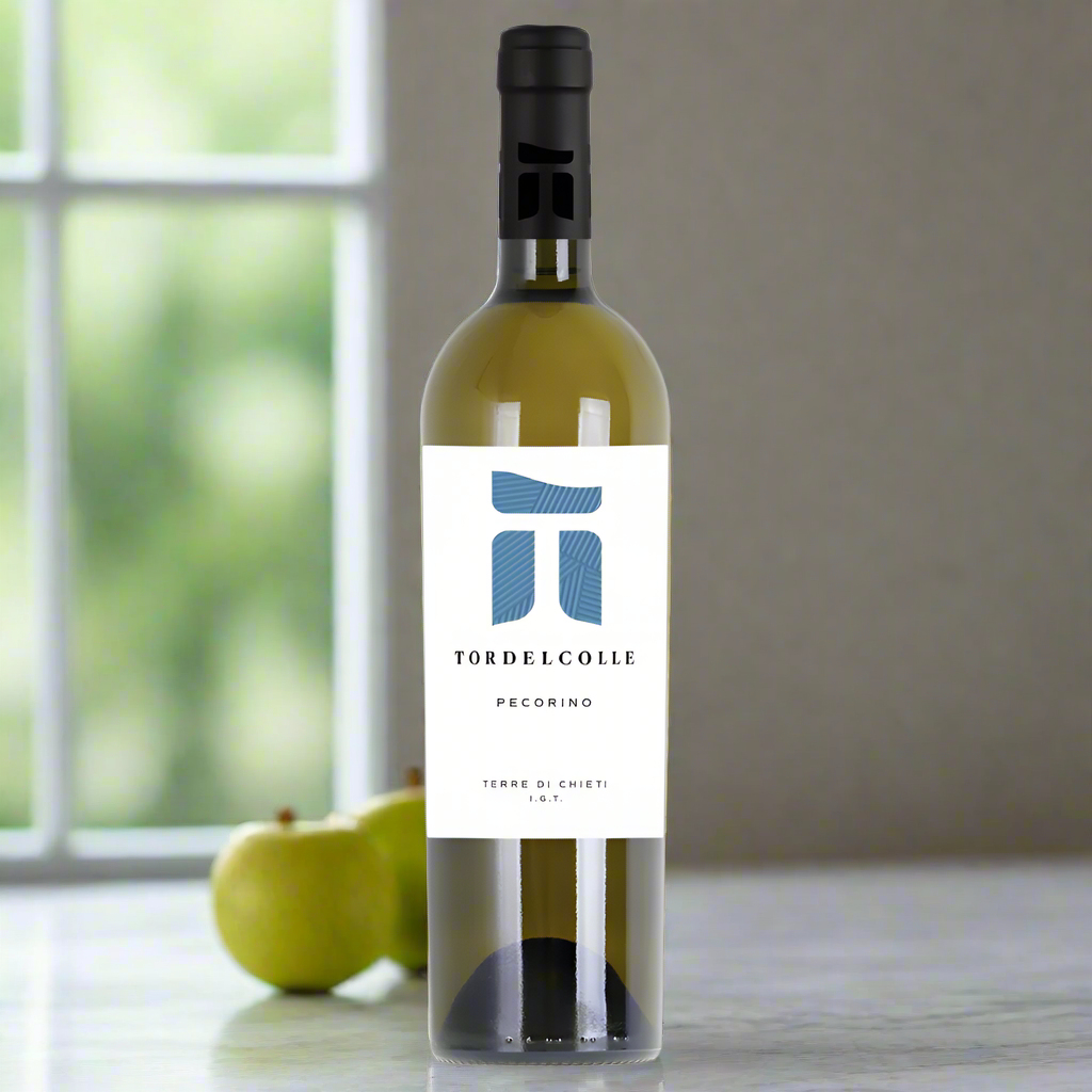 Tor del Colle Pecorino Terre di Chieti bottle on marble counter with lemons, apples, and olives.