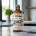 The Spirit of Bristol London Dry Gin bottle on marble kitchen counter with lemons and basil in a bright modern flat