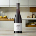 Whale Point Merlot bottle with blackberries and bay leaves on wood counter in modern kitchen