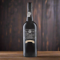 Bottle of Windsor Special Reserve Port on a dark wooden table with moody lighting. 