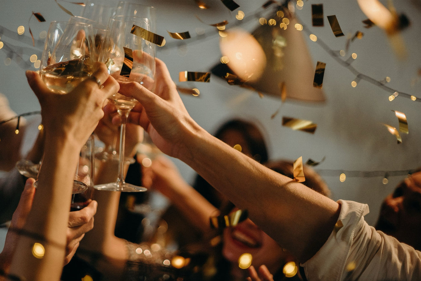 Friends raising wine glasses in a toast at a celebration. Photo: cottonbro studio, Pexels