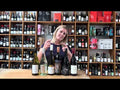 Unboxing a curated case of Australian and New Zealand wines, featuring red and white bottles on a wooden counter.